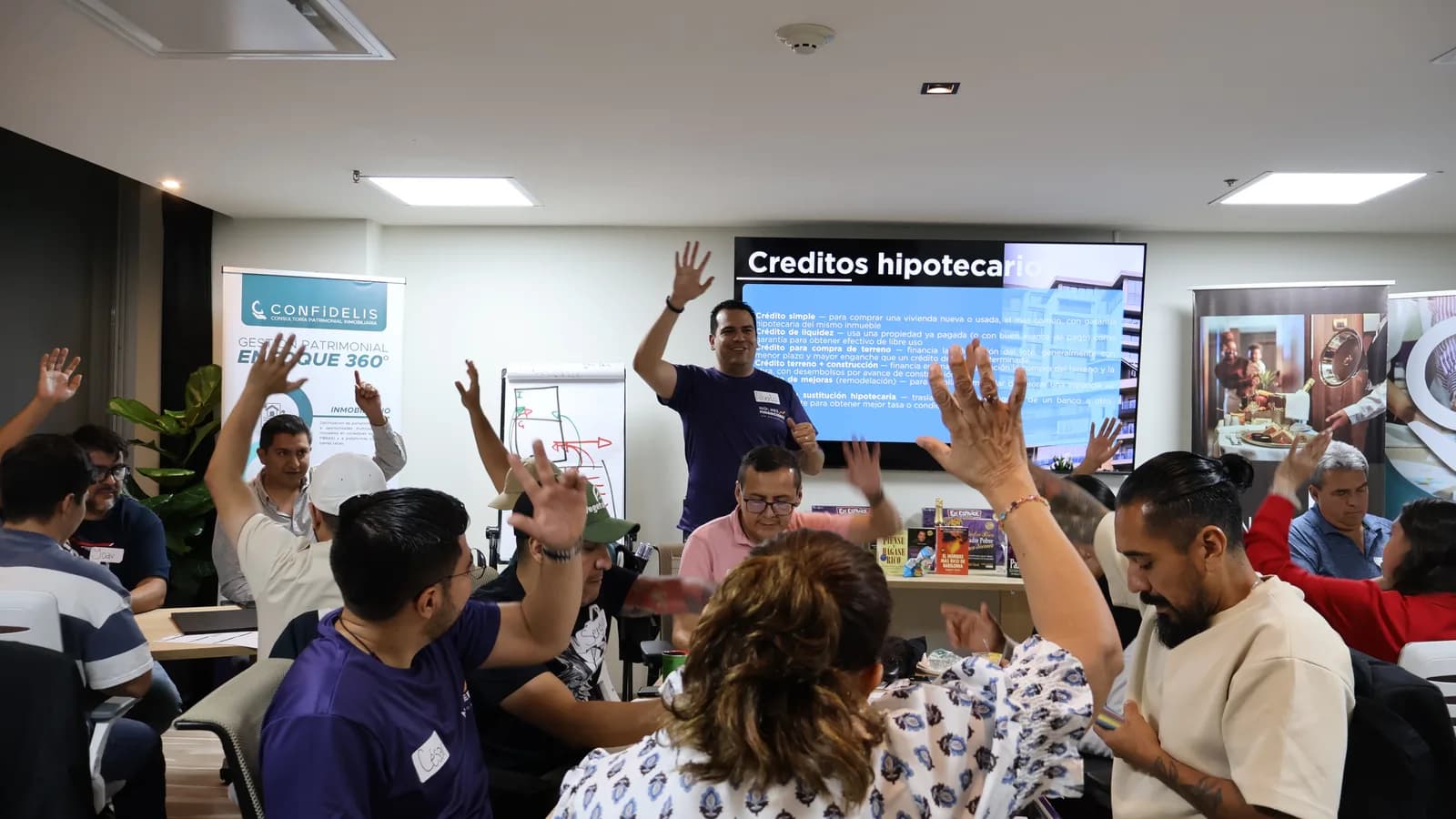 Facilitador explicando los tipos de crédito hipotecario mientras los asistentes levantan la mano